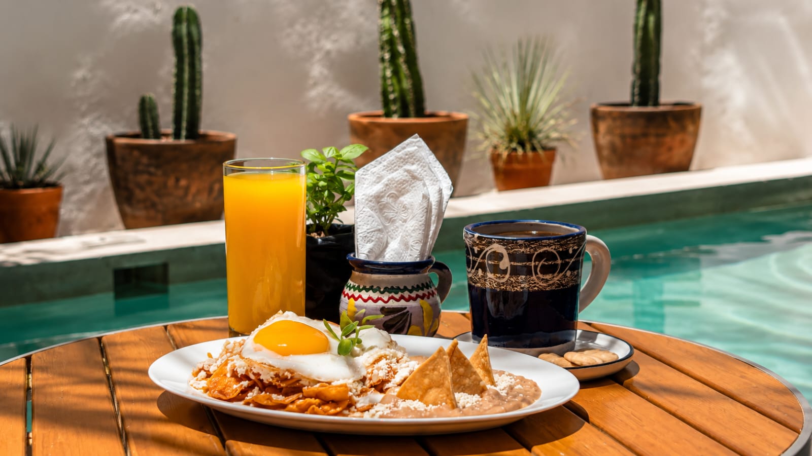 Chilaquiles, café de olla and juice on Mi Yoya's outdoor patio by the pool